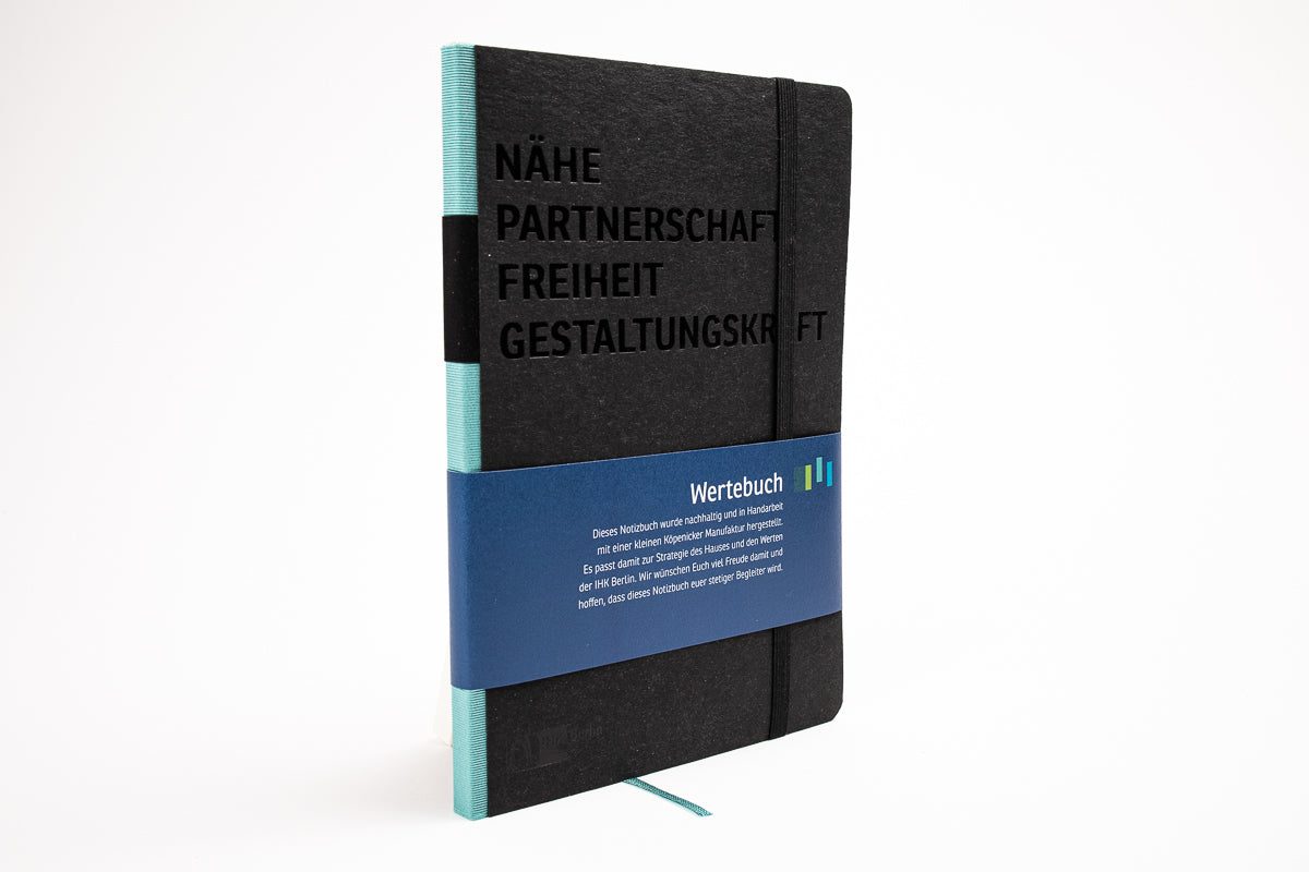 Schwarzes Notizbuch mit Logo Prägung und individueller Banderole im Corporate Design Wertebuch IHK Berlin