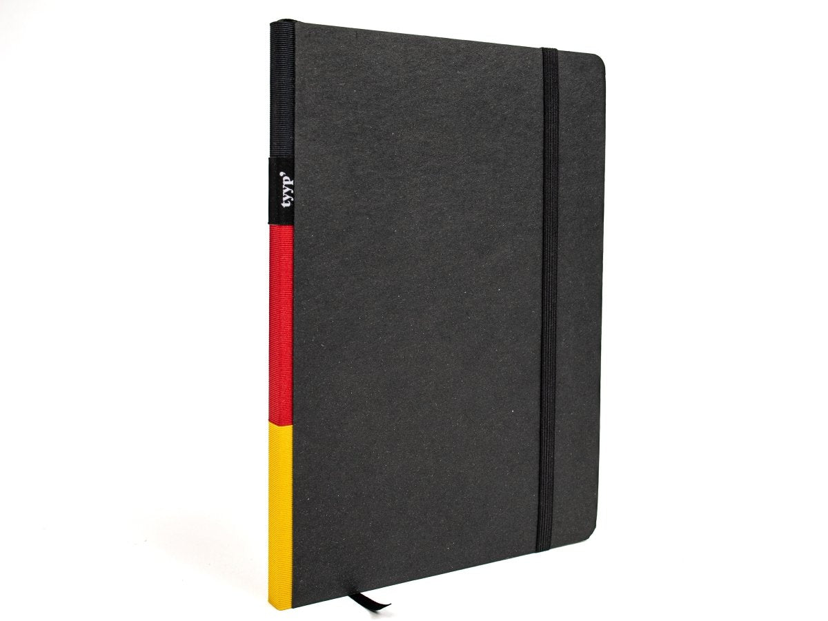 Notizbuch A5 „Klassik“ blanko, perforiert, mit Gummiband, Einband Schwarz | Bundfarbe: Deutschland-Flagge